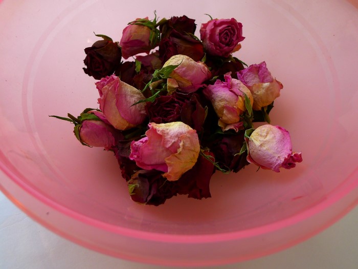 Dried pink and red roses in a pink bowl