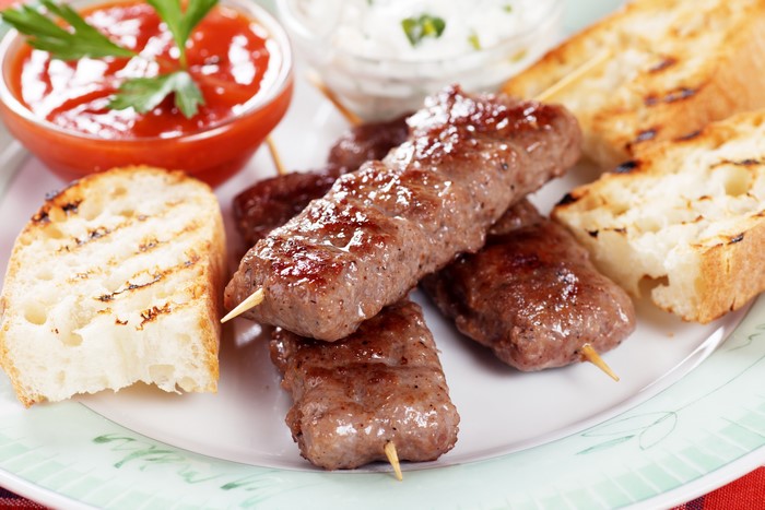Grilled meat skewers with bread and ketchup