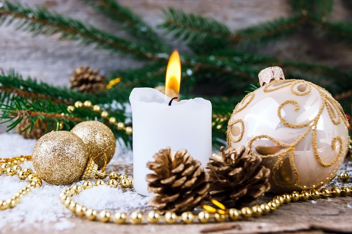 Christmas candle with ornaments and pine cones