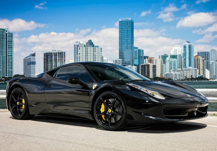 Black Ferrari 458 Italia in front of Miami skyline