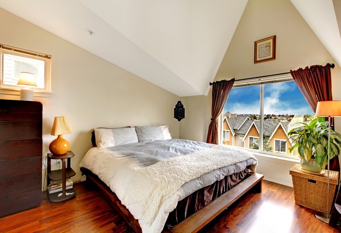 Bedroom with a large window overlooking houses