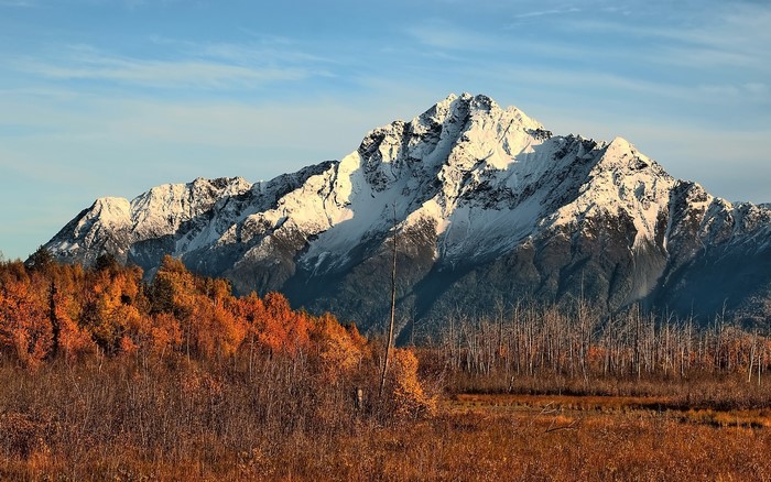 Snow-capped mountains in autumn with colorful trees