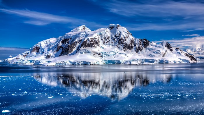 Snow-covered mountains reflected in the sea