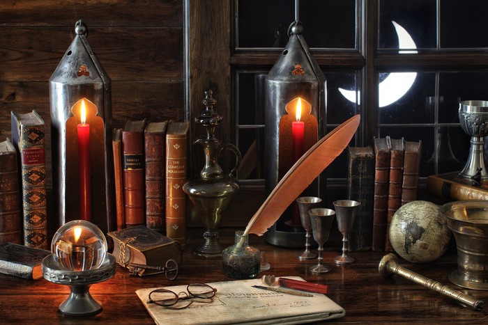 Desk with books, candles, and writing tools