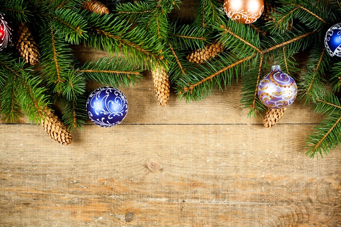 Christmas branches with pine cones and ornaments on wood