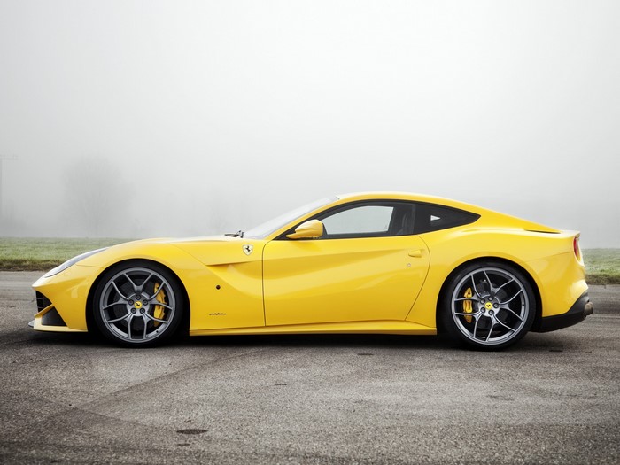 Yellow Ferrari F12berlinetta parked on asphalt