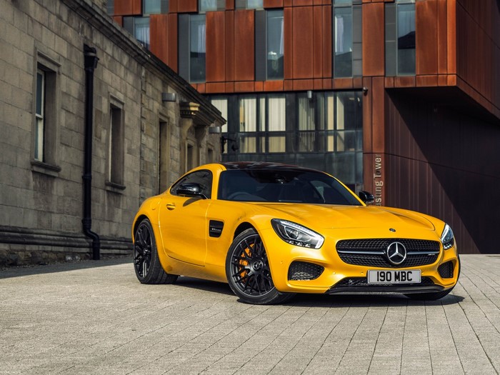 Yellow Mercedes-Benz AMG GT S parked on cobblestone street