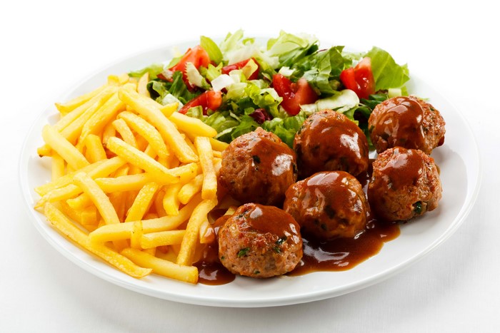 French fries, salad, and meatballs with gravy