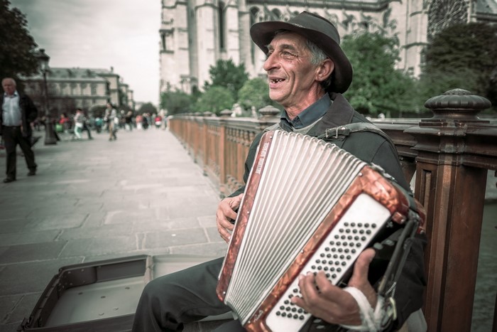 Man playing accordion on a bridge in Paris