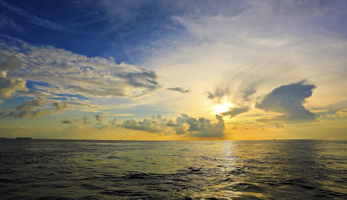 Sunset over the ocean with dramatic clouds