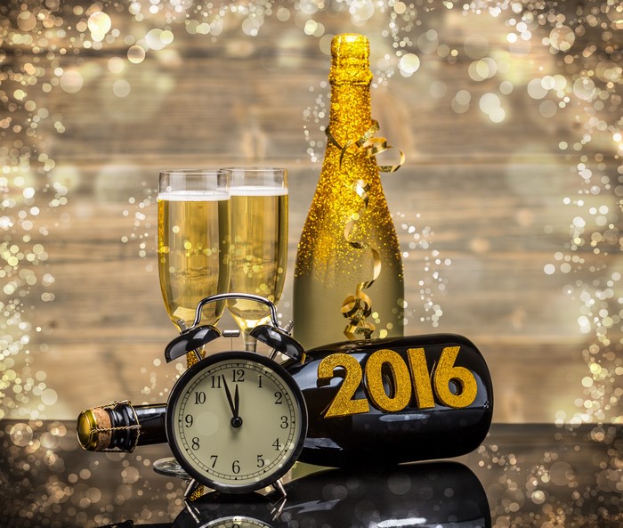 Champagne bottle and glasses with 2016 and alarm clock