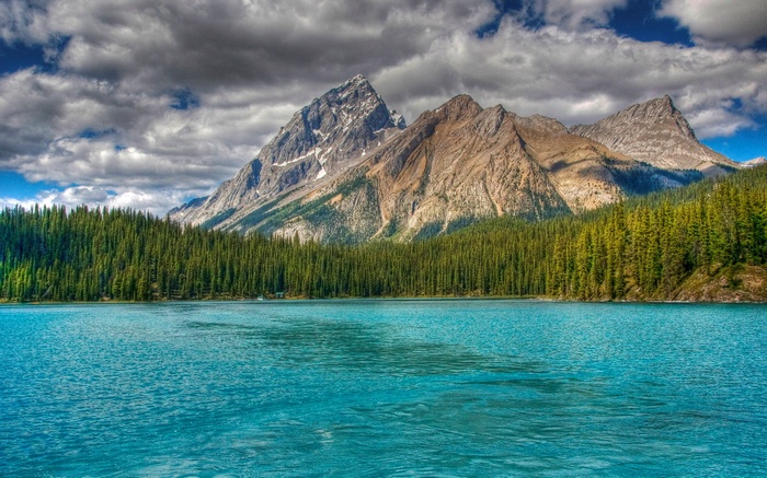 Turquoise lake with pine forest and mountains