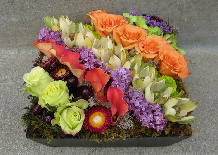 Floral arrangement with roses, callas, and lilac