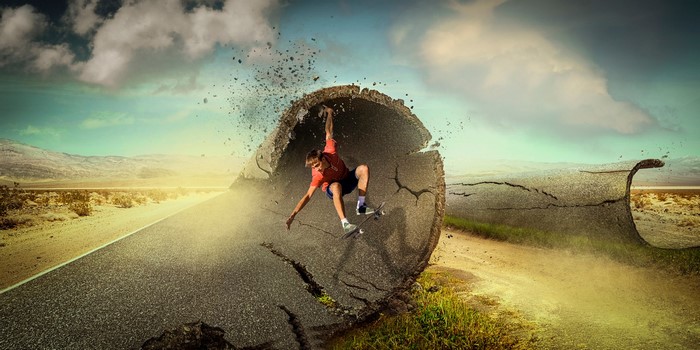 Man skateboarding through a broken road