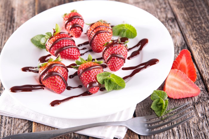 Strawberries with chocolate and mint on a plate