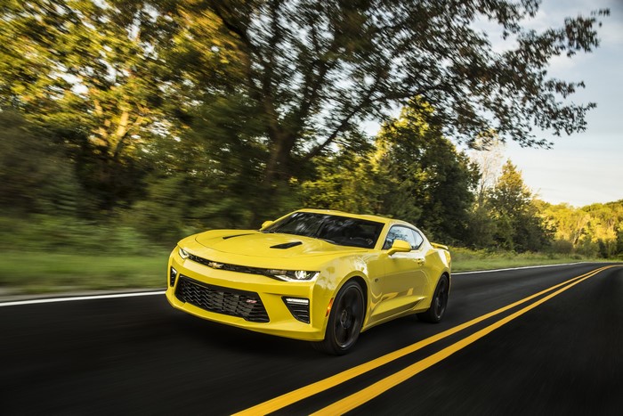 Yellow Chevrolet Camaro SS driving on a road