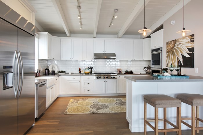 Modern white kitchen with stainless steel appliances and pendant lights