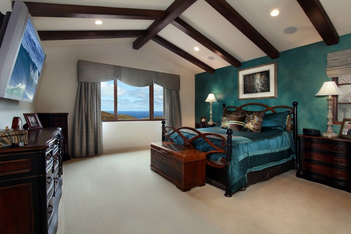 Bedroom with ocean view and dark wood furniture