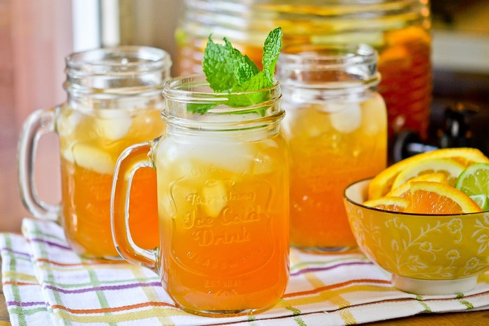 Orange and lime iced drinks in mason jars