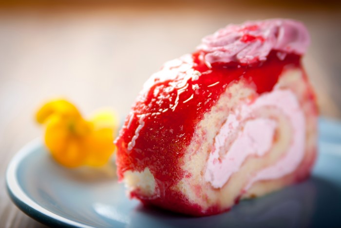 Slice of Swiss roll with strawberry topping