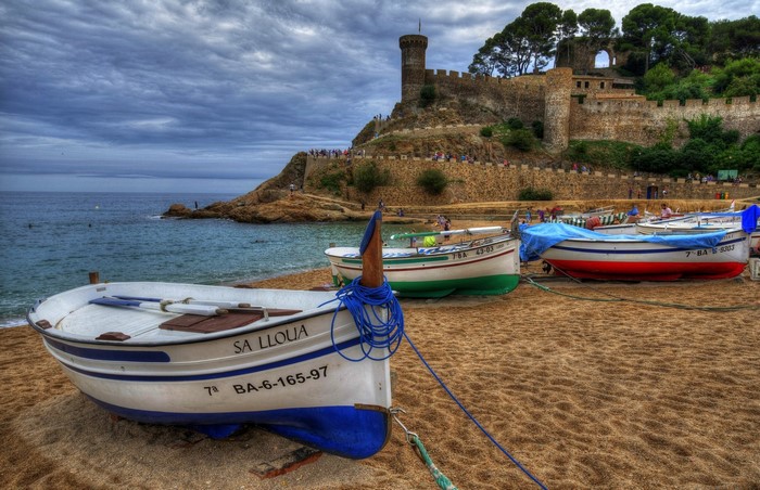 Boats on beach with castle in Tossa de Mar, Spain