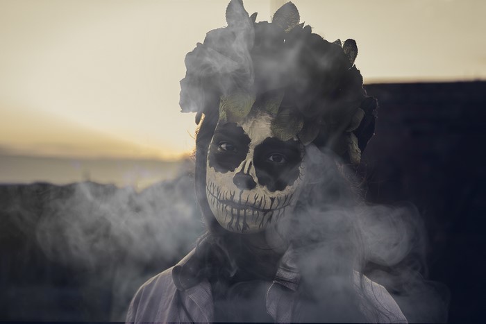 Person with Dia de los Muertos makeup and smoke