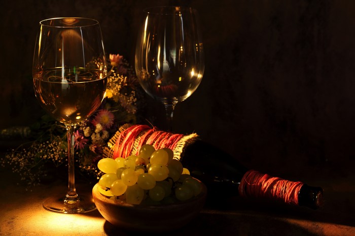 Wine bottle, grapes, and glasses with bouquet