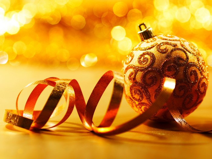 Gold Christmas ornament with ribbon and bokeh lights