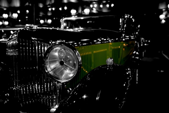 Close-up of a vintage green Bentley car with headlights