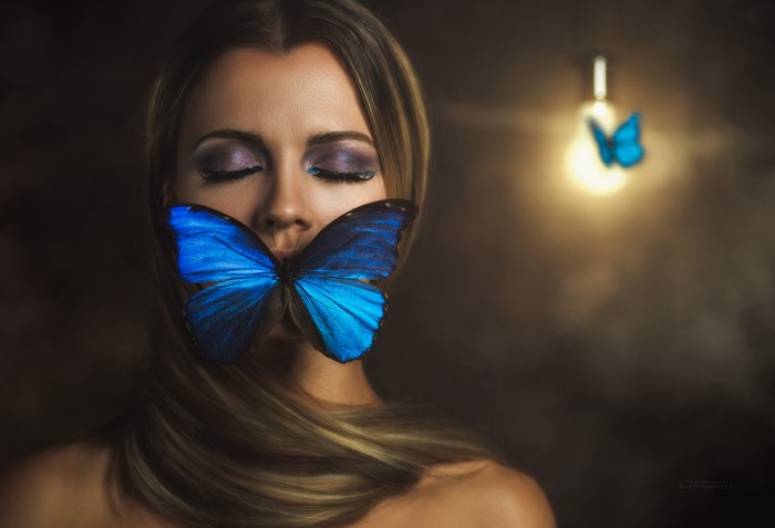 Woman with blue butterfly on her mouth