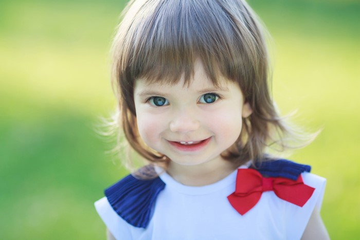 Little girl with blue eyes and red bow