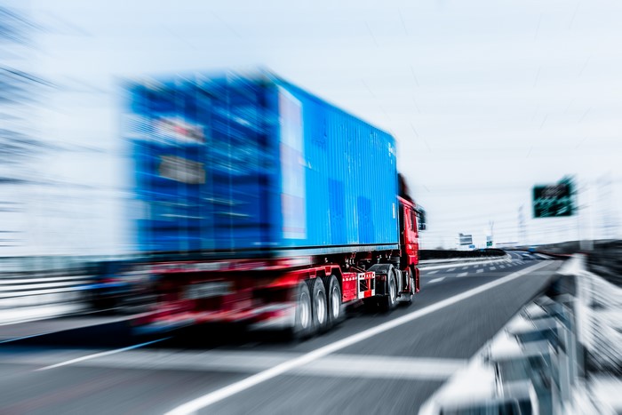 Truck with blue container in motion blur
