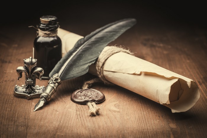 Quill, Inkwell, Scroll, and Wax Seal on Wooden Table