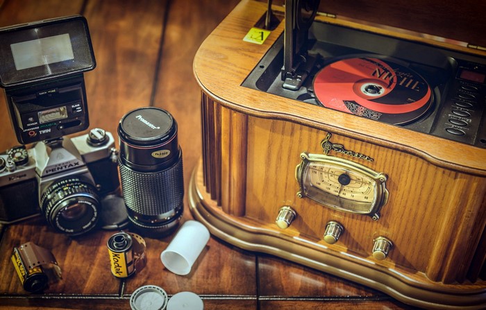 Retro radio, camera, and film on wooden table