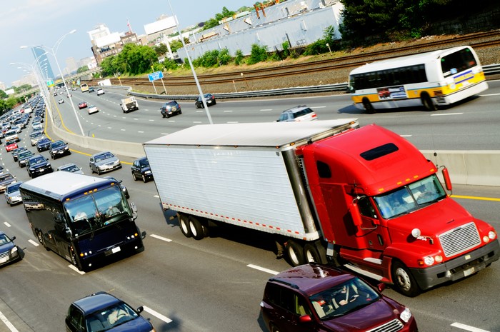 Red Semi-Truck and Bus on Highway