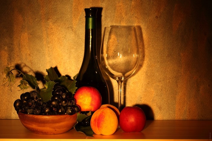 Still life with wine bottle, grapes, peaches, and wine glass