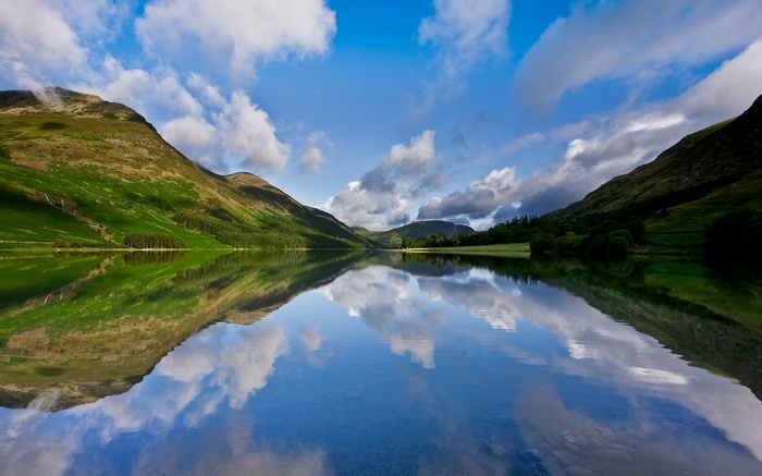 Mountain lake reflecting blue sky and clouds