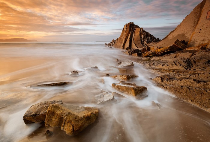 Rocky coast with waves at sunset