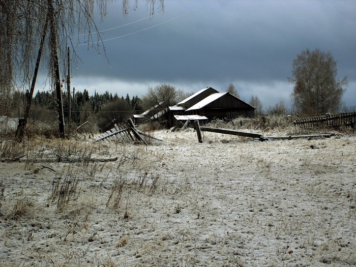 Winter scene with abandoned farm buildings and snow