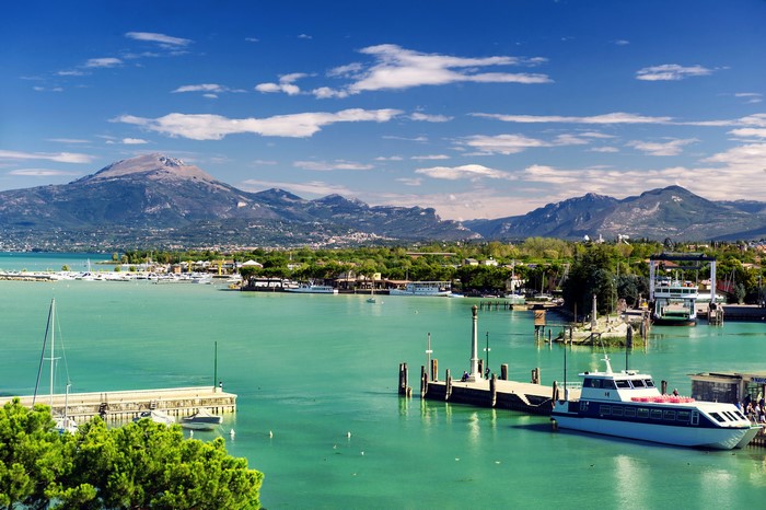 Boats docked in a harbor with mountains in the background