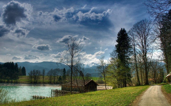 Wooden boathouse on a lake with mountains in the background