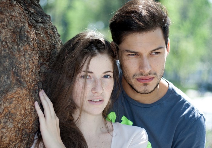 Couple leaning against a tree