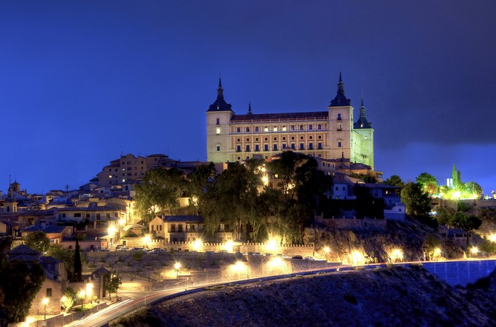 Alcázar of Toledo at night with city lights