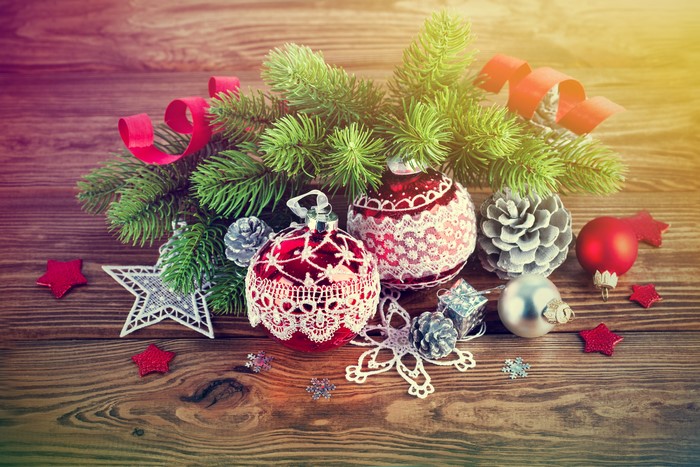 Christmas ornaments and pine branches on wooden background