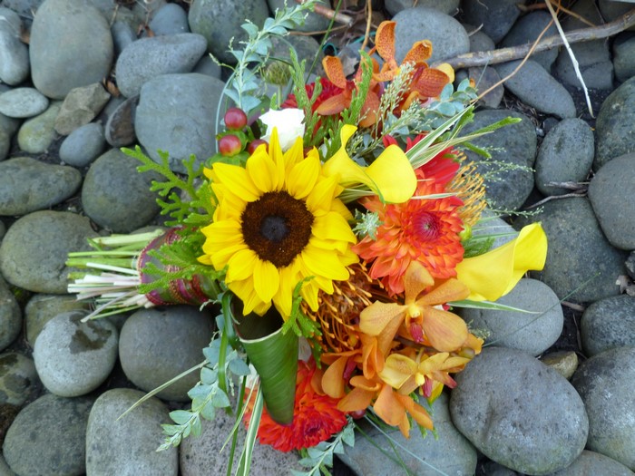 Bouquet of sunflowers, dahlias, orchids, and calla lilies on stones