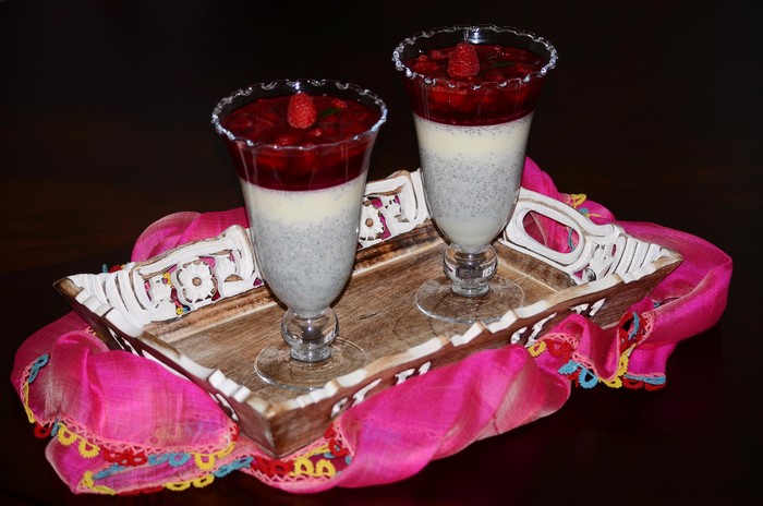 Two desserts with raspberries on a tray