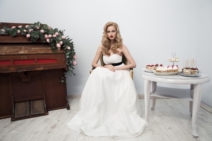 Bride Sitting by Piano and Dessert Table