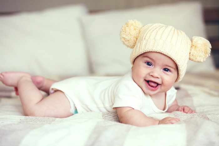 Baby wearing a winter hat with pom-poms