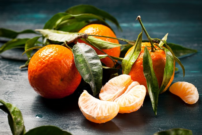 Tangerines with leaves on a dark background