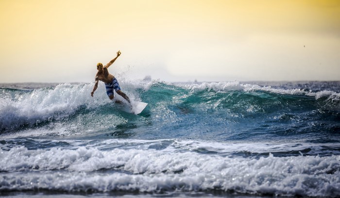 Surfer riding a wave at sunset